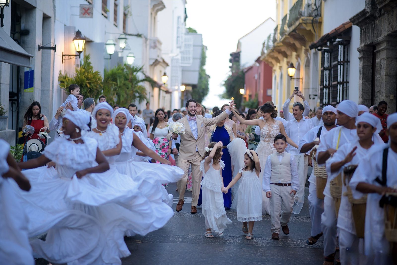 Newlyweds parading through the streets of the walled city with palenqueras and drummers