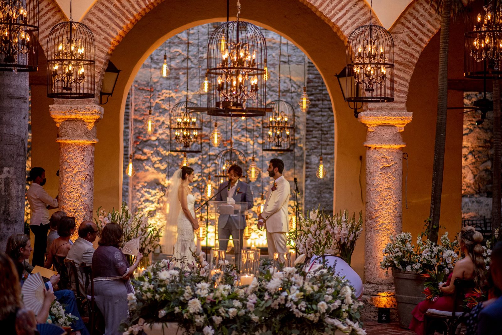 Wedding ceremony under colonial arches with birdcage chandeliers in Cartagena