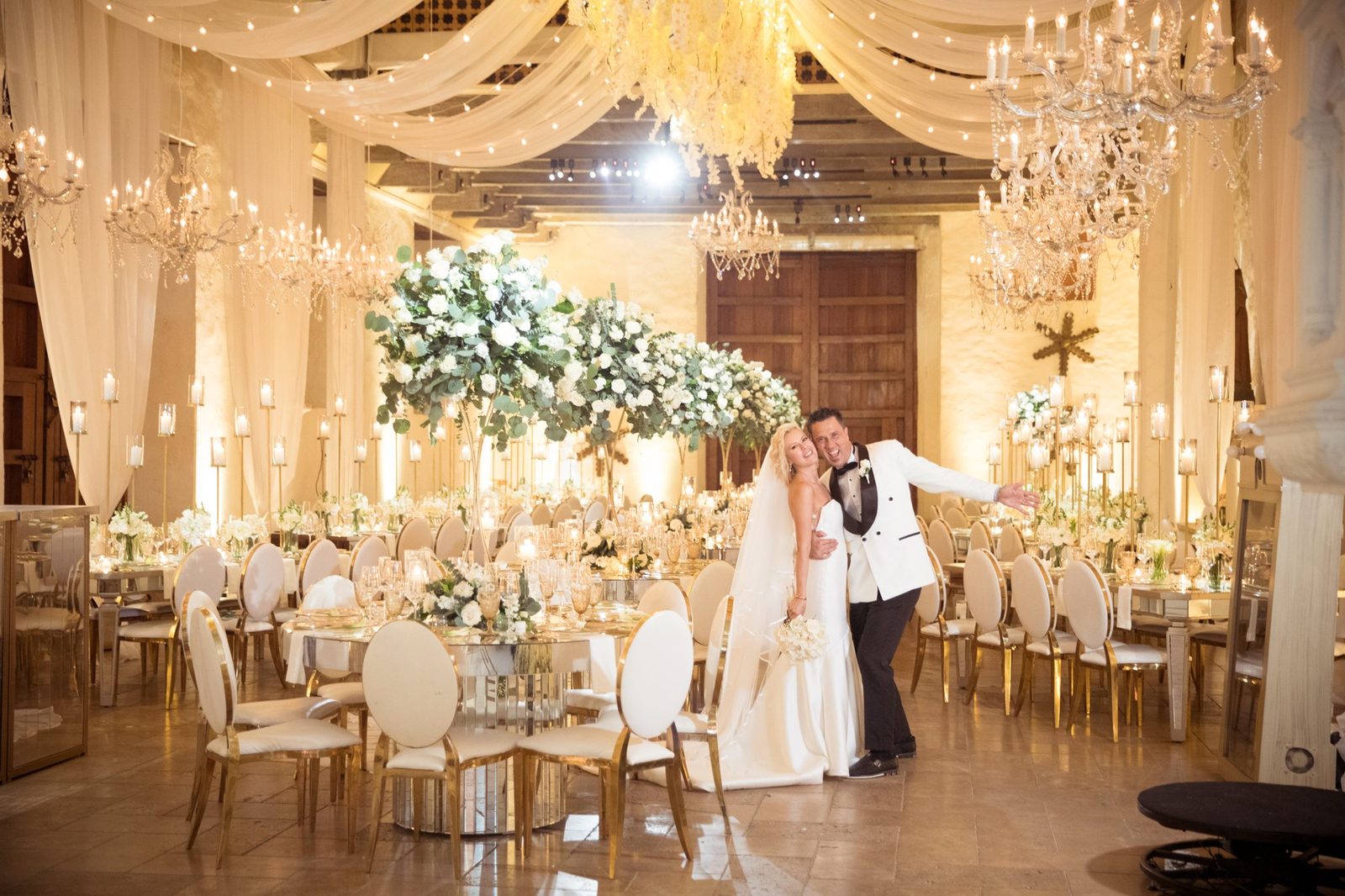 Elegant reception with chandeliers and gold chairs in a colonial hall