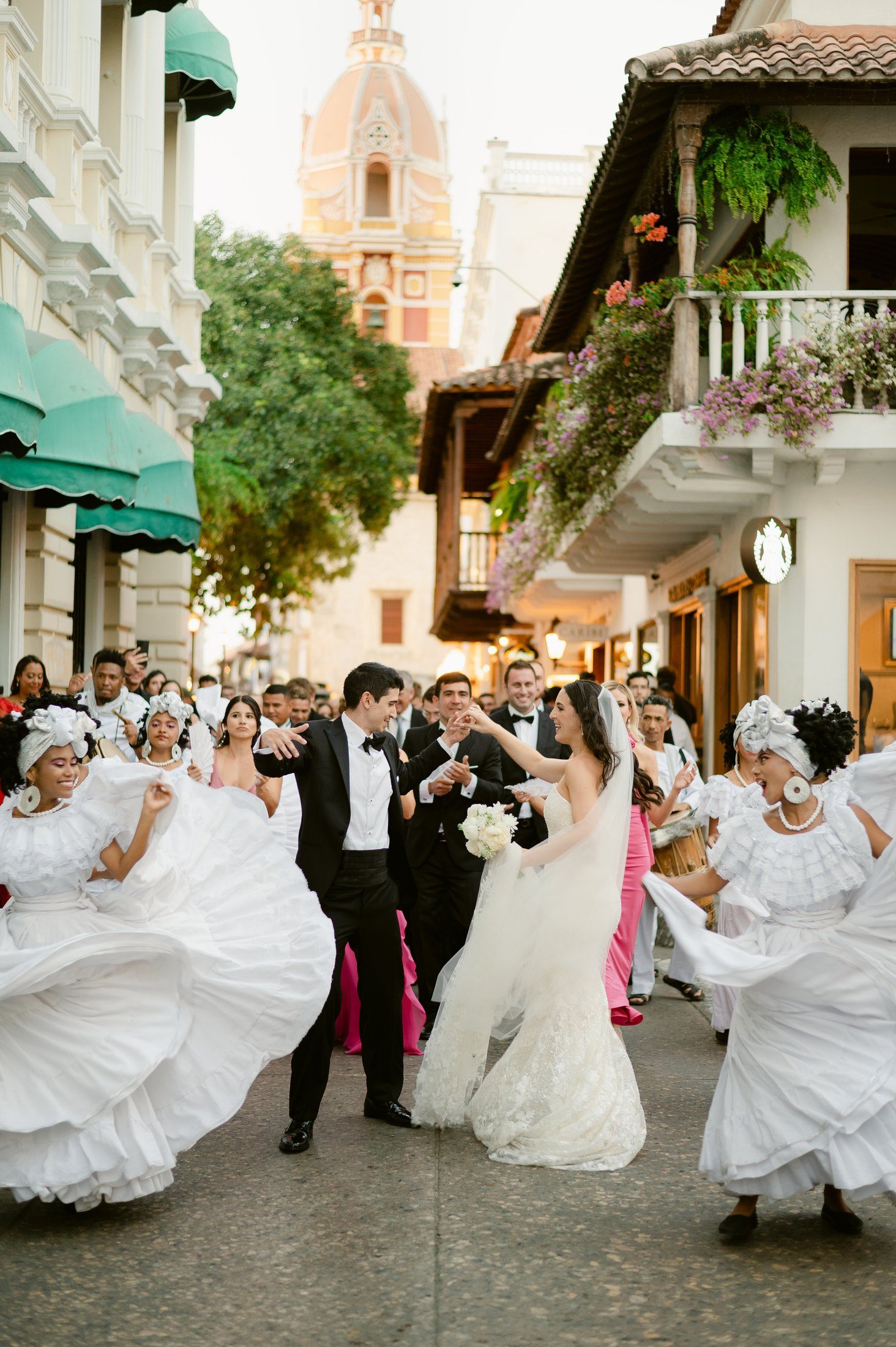 Couple under a ceiling of white flowers at their reception