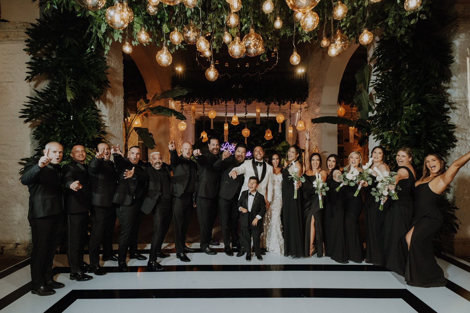 Wedding party posing in a colonial hall with checkered floors